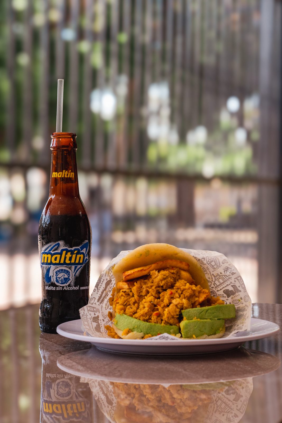 Arepa criolla con relleno de pollo y malta bien fría